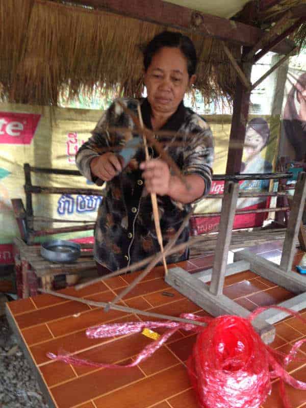 woman starting to wind yarn to prepare for dyeing is an example of the Khmer Hol program topic
