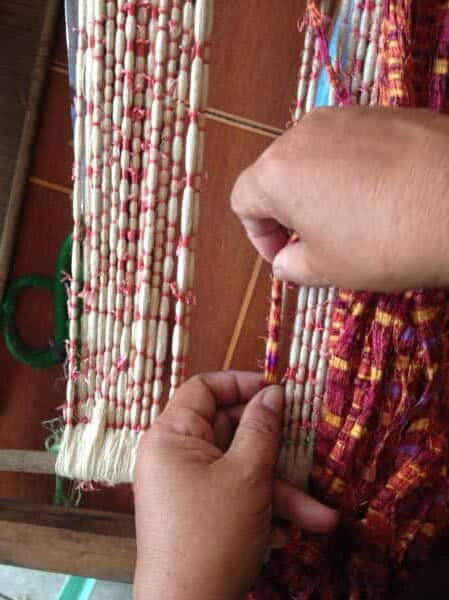 close up showing bundles of yarn wrapped in spots to serve as a resist when dyeing is an example of the Khmer Hol program topic