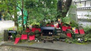 Two small altars surrounded by red flags and vases of flowers in Japan